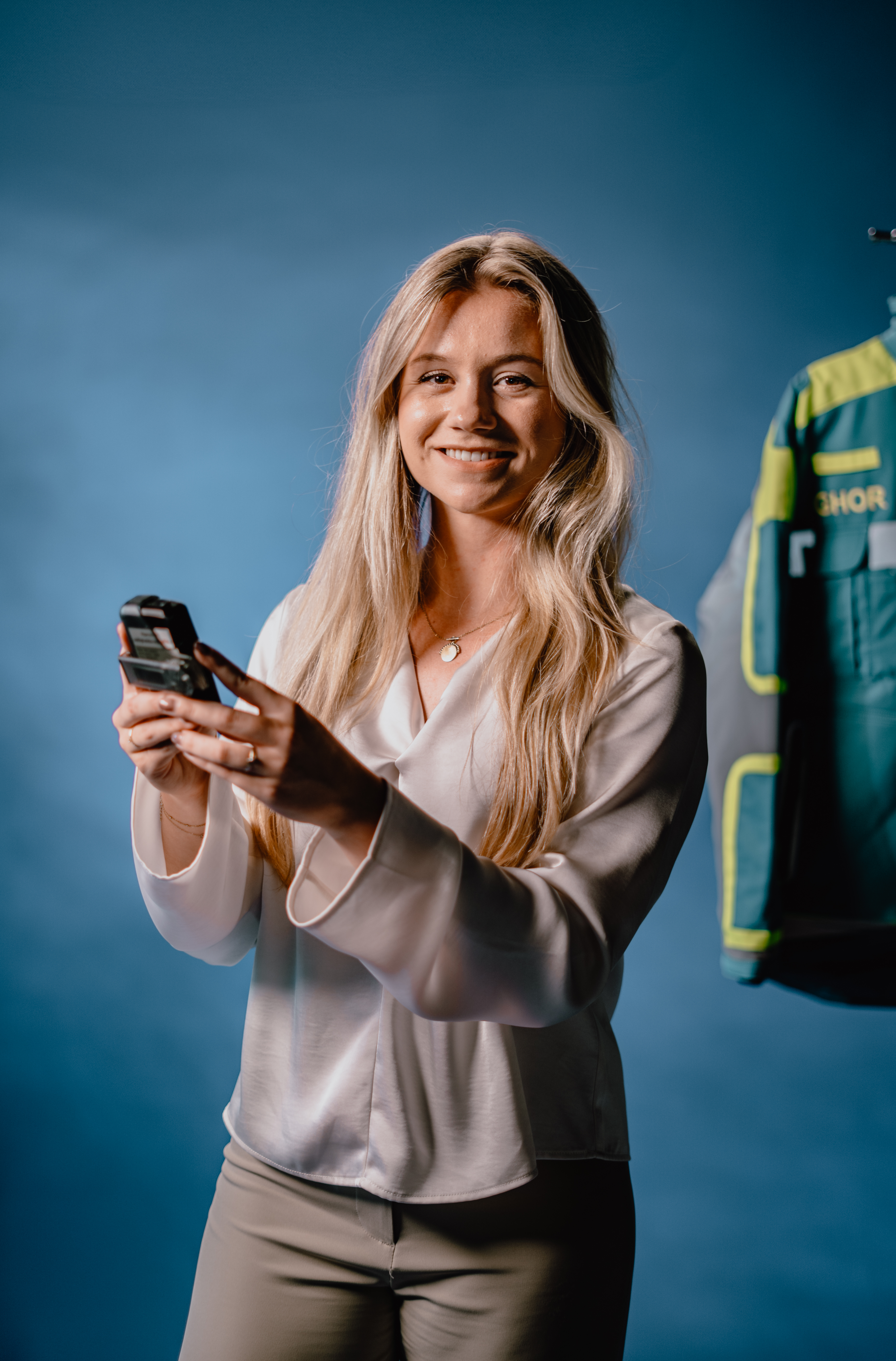 Lachende vrouw houdt mobiele telefoon met twee handen vast