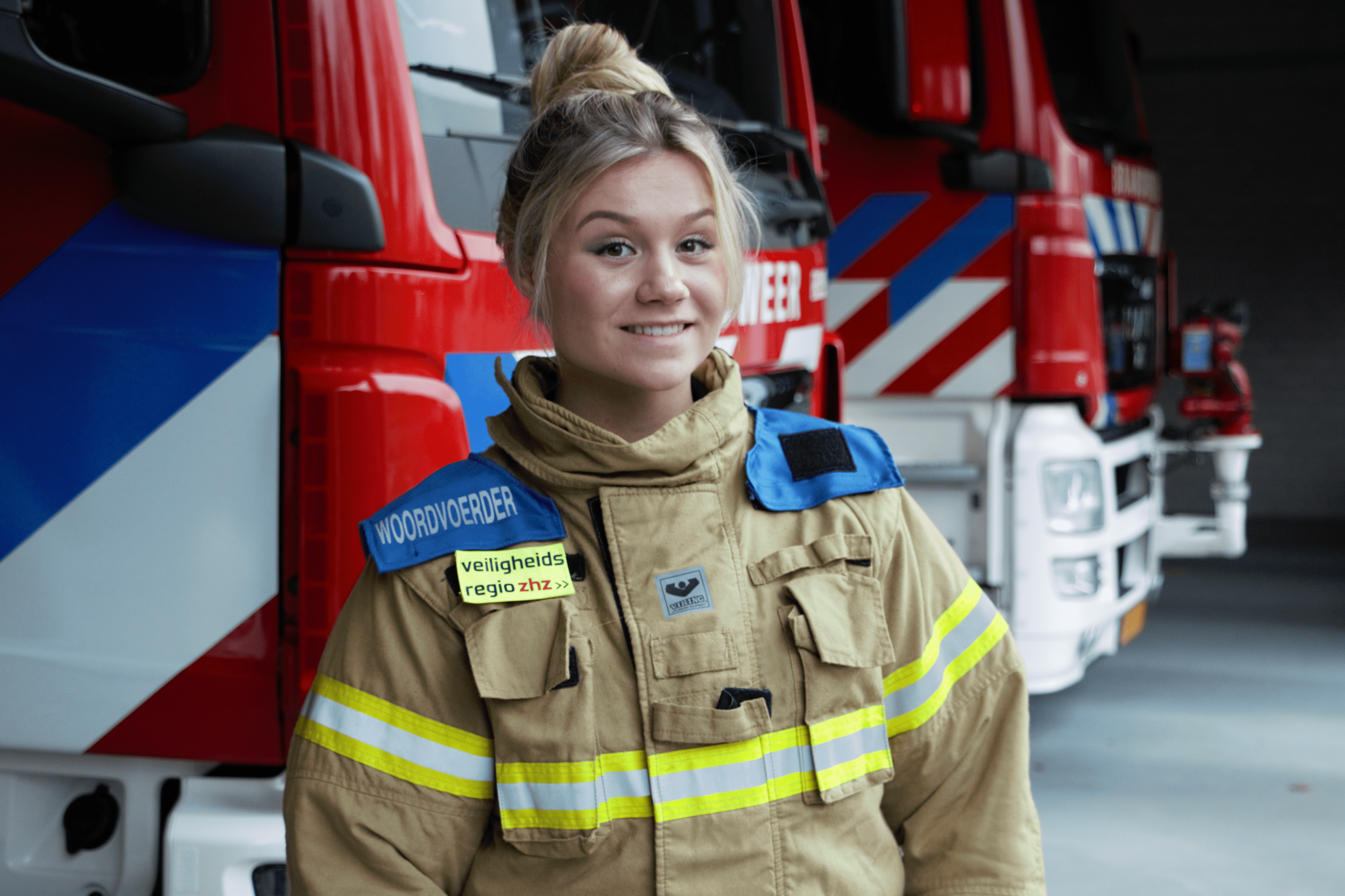 Woordvoerder Julia Kruit in een blusjas voor een brandweerauto