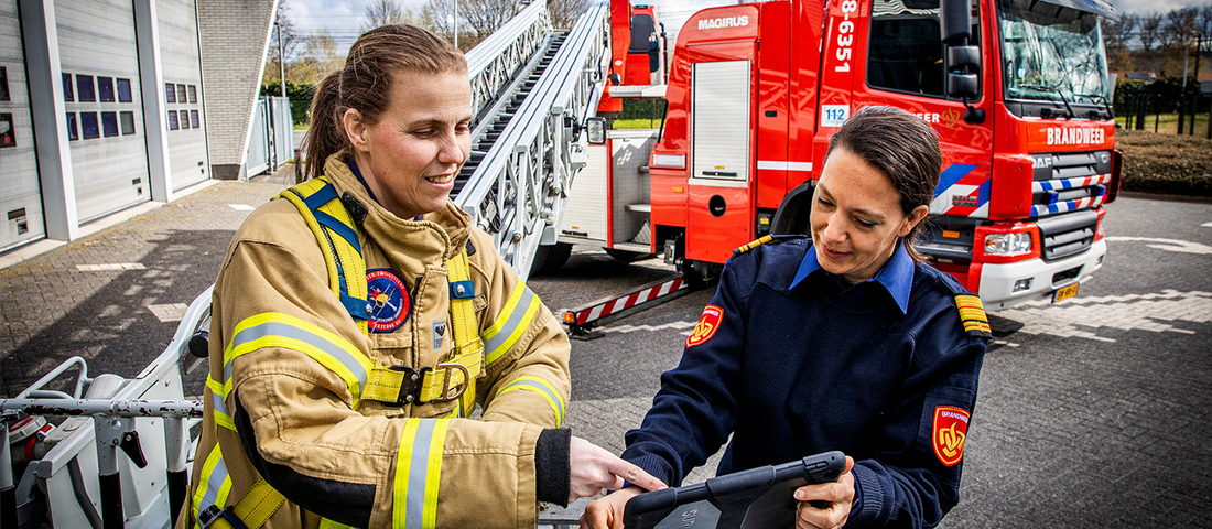 Caren en Ilse in overleg voor een brandweerauto