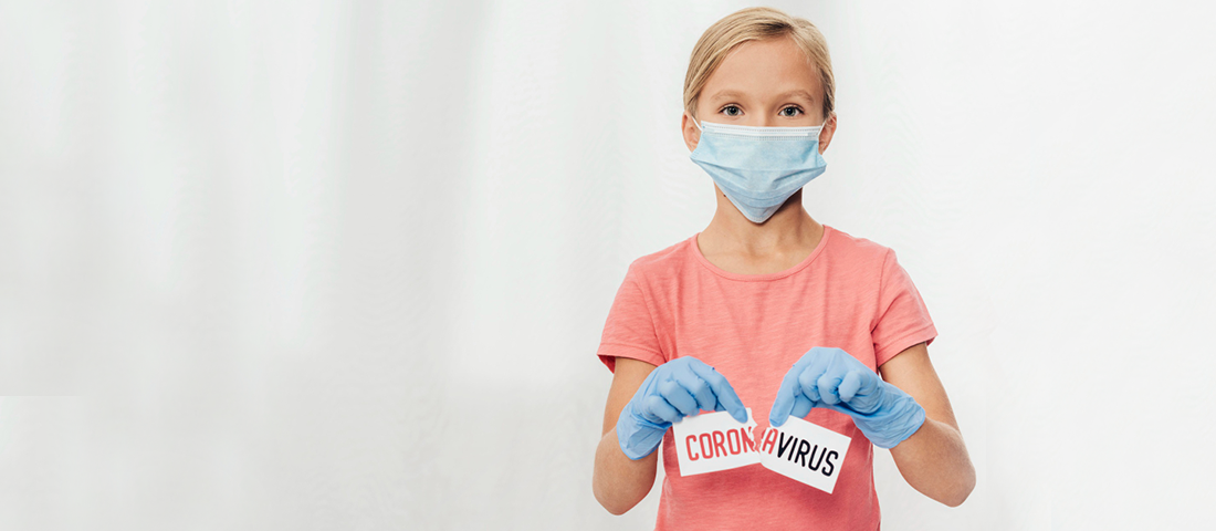 Meisje met een mondkapje die symbolisch een kaartje met de naam coronavirus doorscheurt 