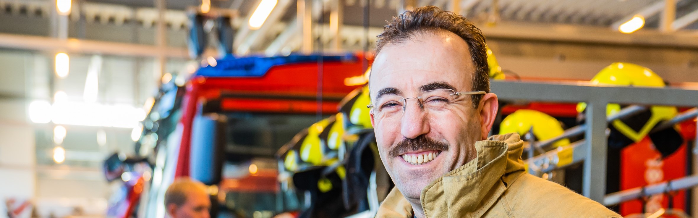 Cemal poserend voor brandweerauto in uitrukhal