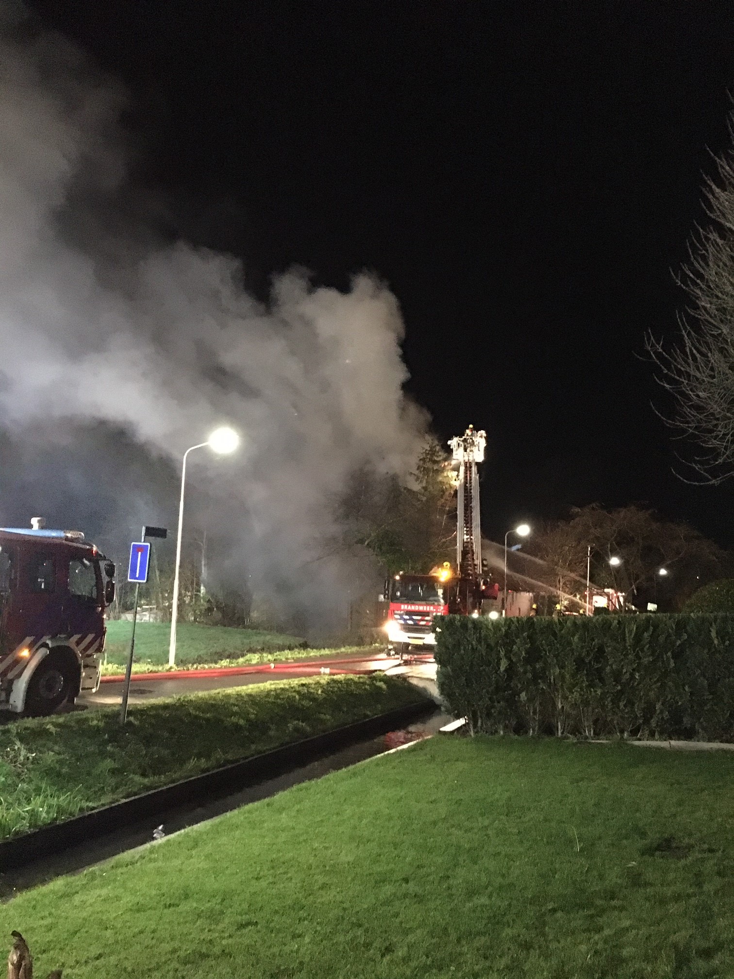 Brandweer blust vanuit hoogwerker