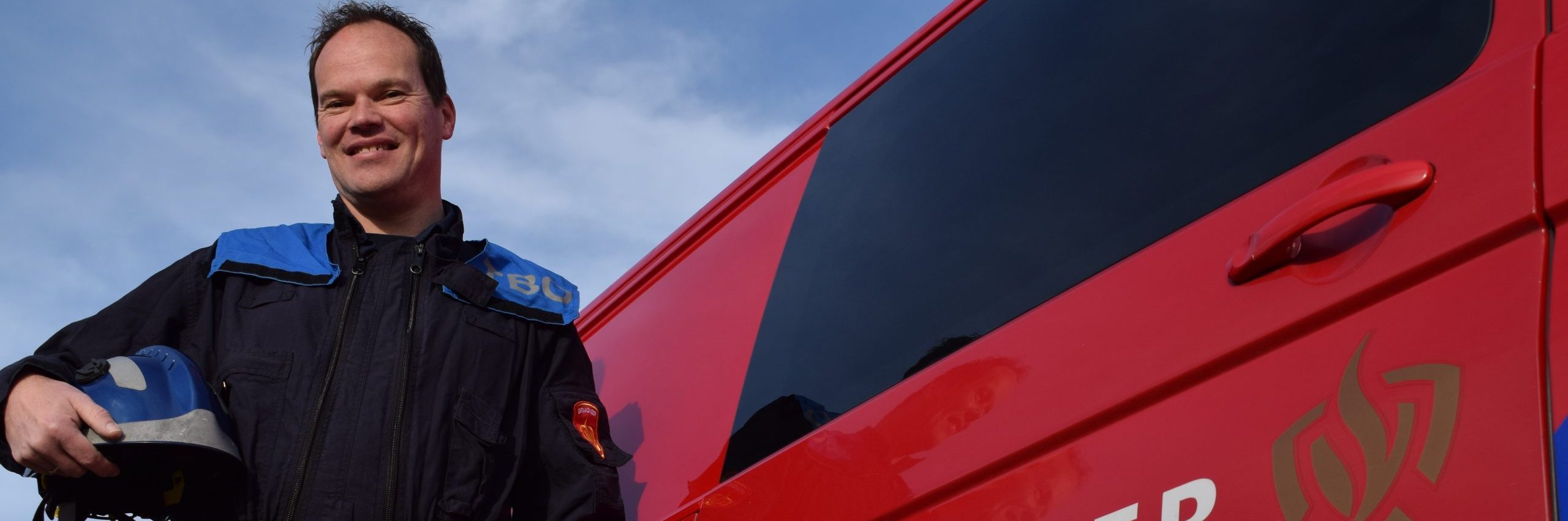 Jeroen Naaktgeboren staat naast brandweerauto