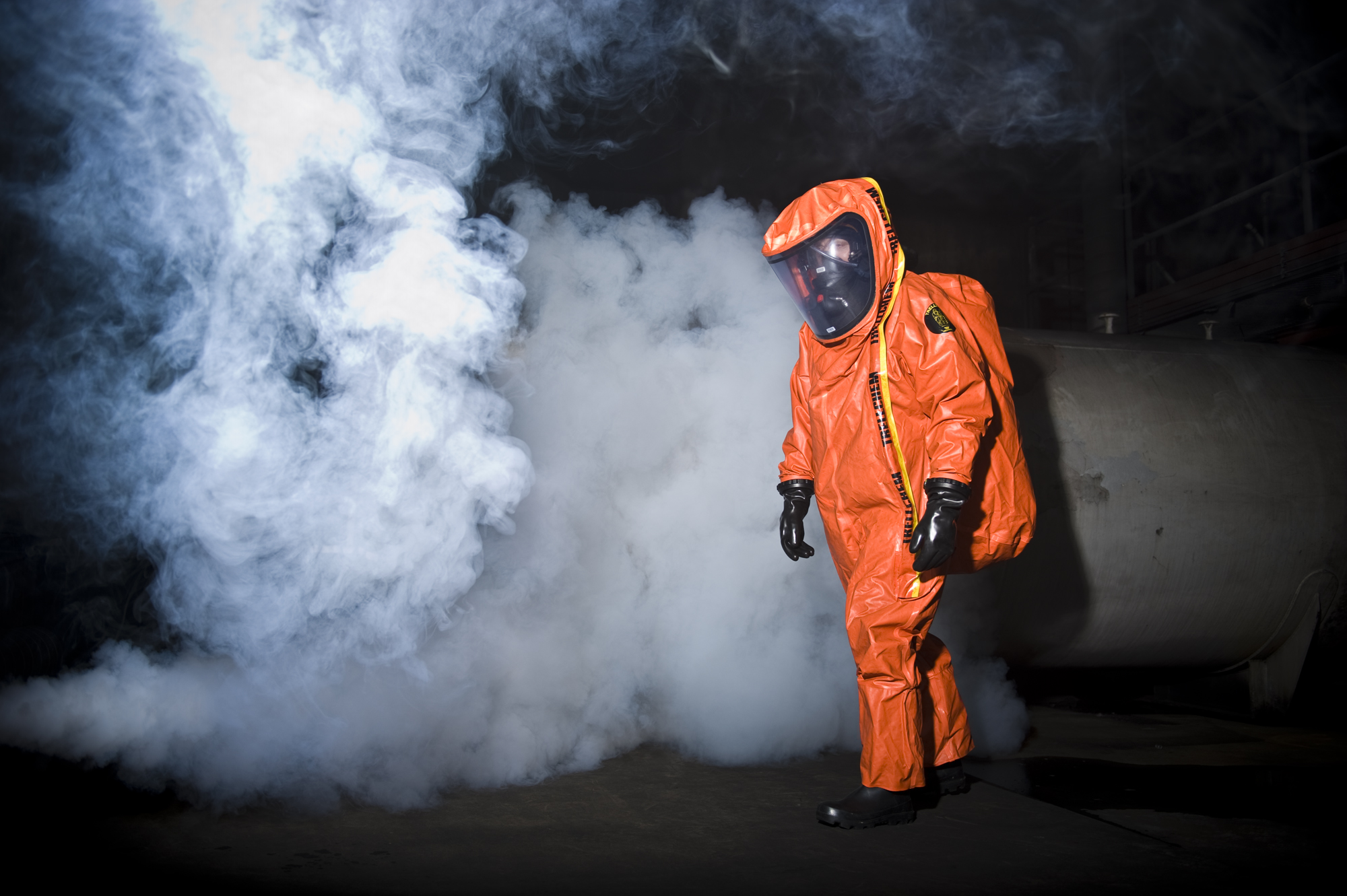 Brandweerman in oranje beschermingspak tegen gevaarlijke stoffen