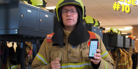 Brandweerman Michel met telefoon in hand
