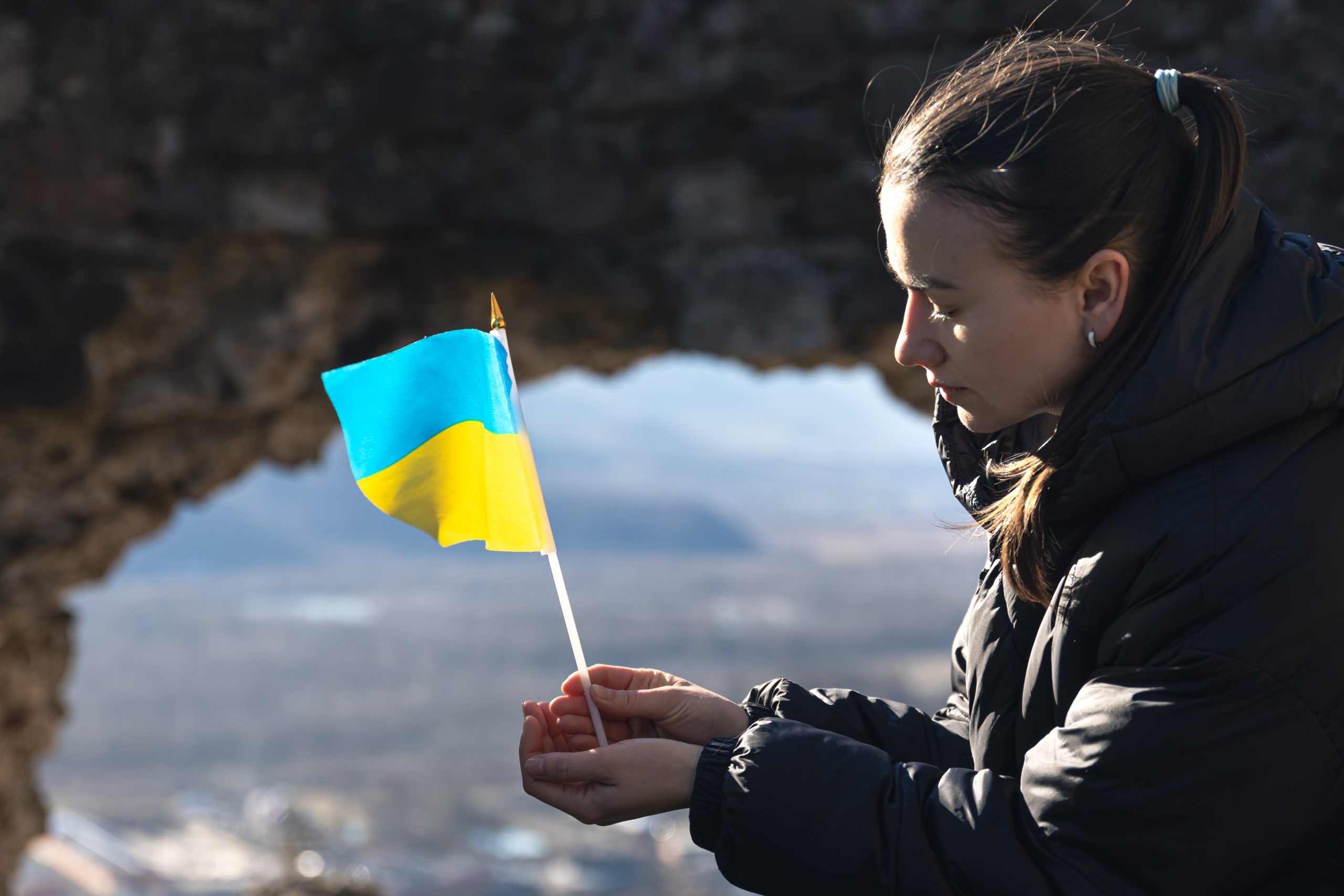 A young sad woman with the flag of Ukraine in her hands, the concept of war in Ukraine.