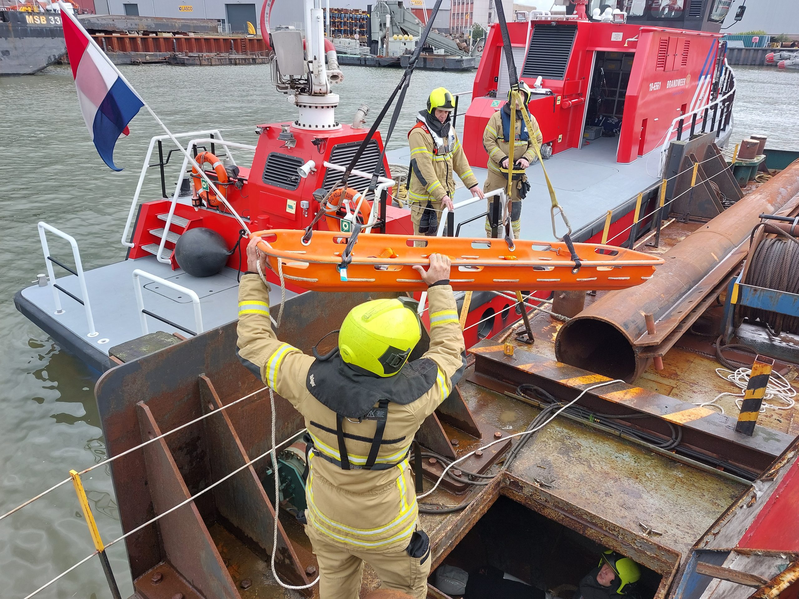 Brandweermannen met brancard aan takel