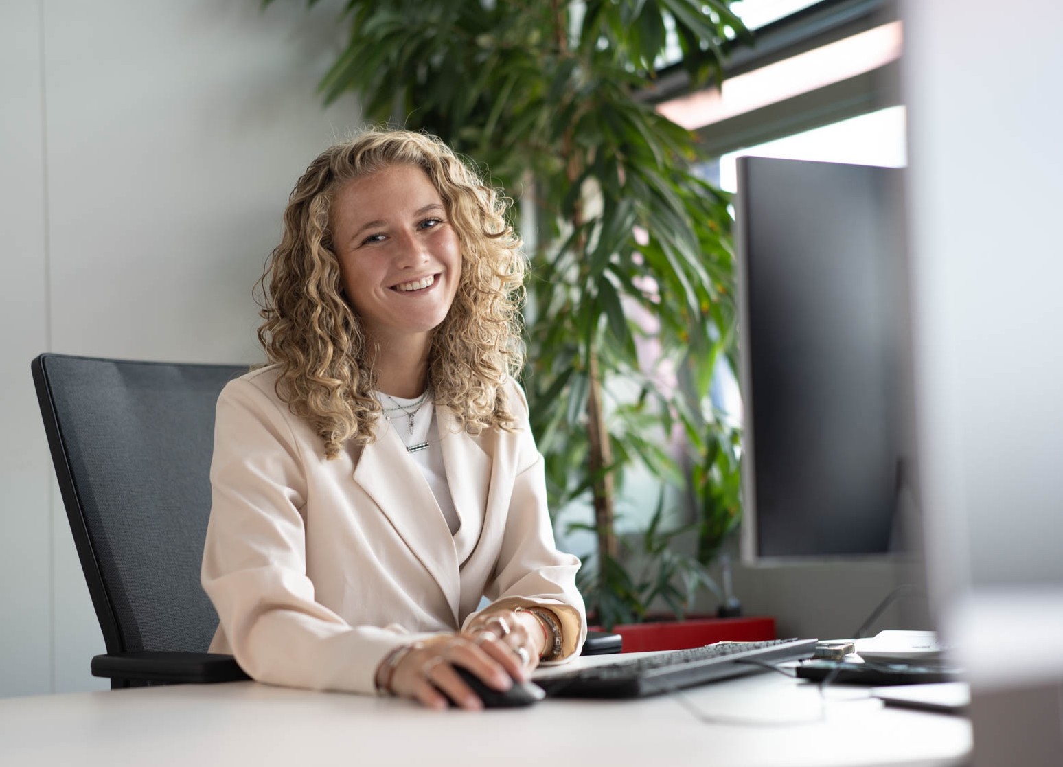Stagiaire in kantooromgeving achter bureau