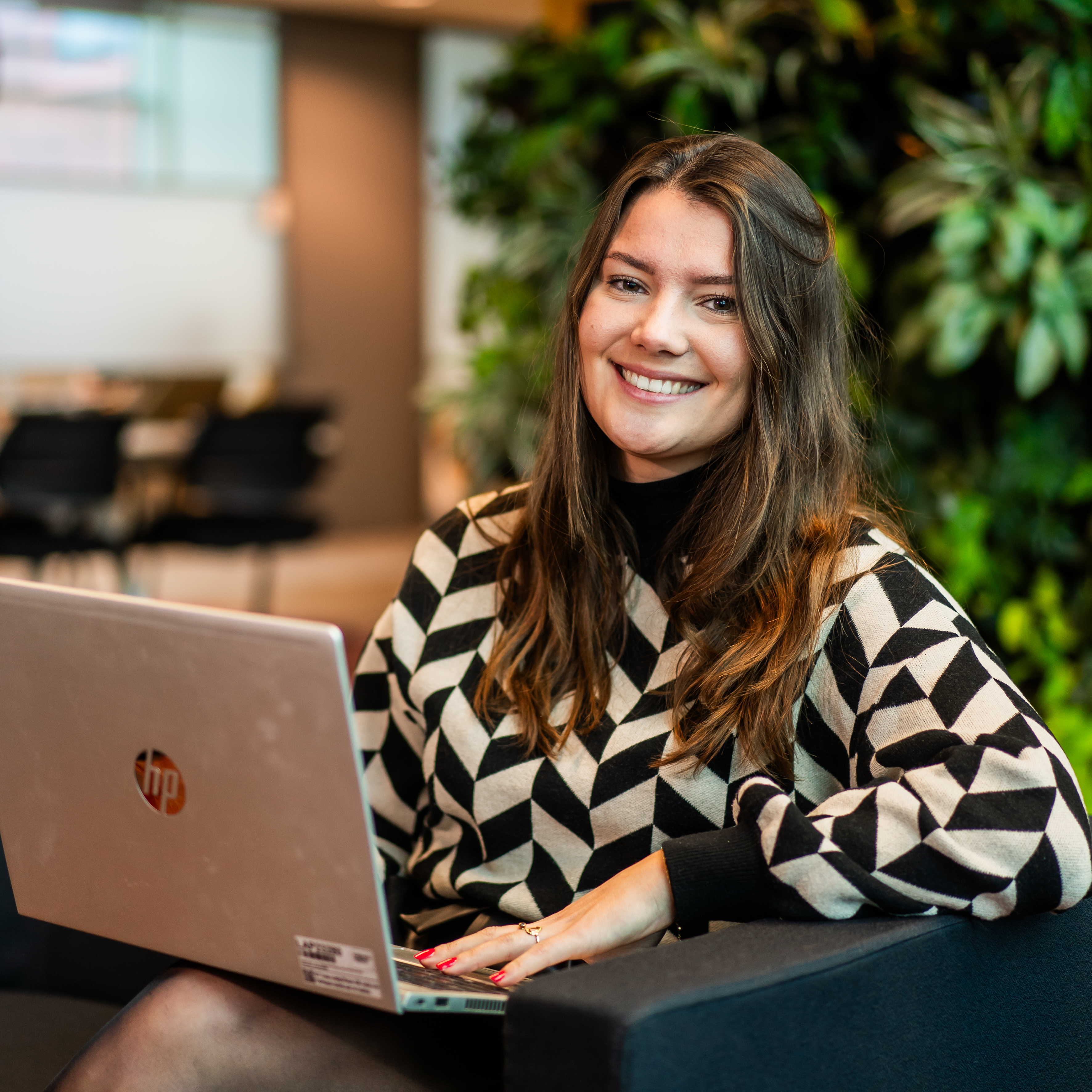 Lisa met laptop lachend kijkend in de camera